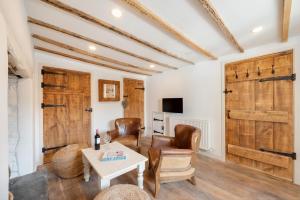 a living room with wooden doors and a table and chairs at 3 Bed in Croyde oc-croyco in Croyde