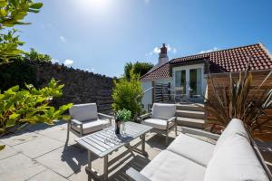 a patio with two chairs and a table and chairs at 3 Bed in Croyde oc-croyco in Croyde