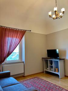 ein Wohnzimmer mit einer blauen Couch und einem Fenster in der Unterkunft Don Pasquale B&b in Picciano