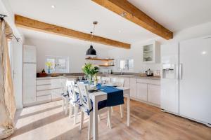 a kitchen with white cabinets and a blue table and chairs at 3 Bed in Croyde oc-croyco in Croyde