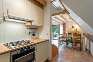 a kitchen with a stove top oven next to a dining room at Riet&Rust in Lanaken +29 photos