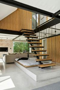 a bedroom with a bed and a spiral staircase at Fjord-Close Cottage With Beautiful View in Hemmet