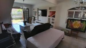 a living room with a couch and a tv at Sobrado em Coroados, Guaratuba PR in Guaratuba +13 photos