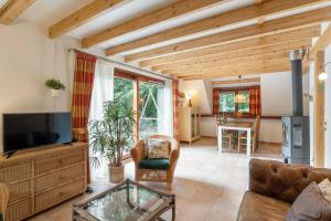 a living room with a couch and a tv at Riet&Rust in Lanaken