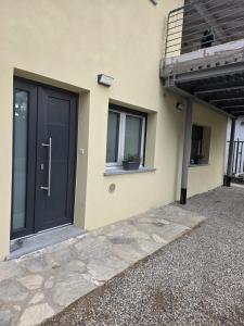 a house with a black door and a window at Cà par durmì in Gravellona Toce