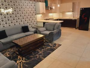 a living room with two couches and a kitchen at Urban Pearl Apartment in Rawalpindi