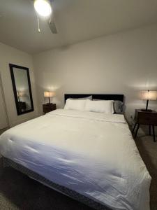 a bedroom with a large white bed with two lamps at The Residences At La Cantera in San Antonio +25 photos