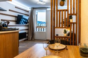 a dining room with a table and two wine glasses at La Canopée Jurassienne in Les Rousses