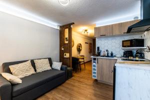 a living room with a couch and a kitchen at La Canopée Jurassienne in Les Rousses