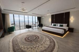a hotel room with a bed and a large window at BALAND HOTEL DUSHANBE in Dushanbe +33 photos