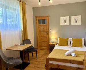 a bedroom with two beds and a table and a desk at Willa Maya in Karpacz +40 photos