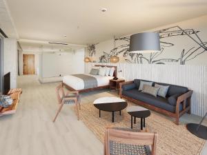 a bedroom with a bed and a living room with a couch at Hyatt Vivid Grand Island Cancun-All Inclusive Adults Only in Cancún