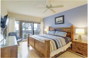 a bedroom with a bed and a ceiling fan at Beachside Tennis 1869 in Hilton Head Island +30 photos