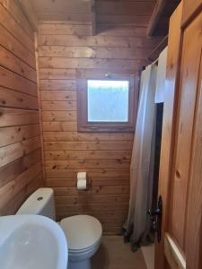 a small bathroom with a toilet and a window at La Cabaña Rural in Paúl