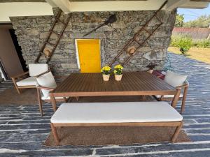 a table and chairs on a patio with a yellow door at Retiro Vale do Douro in Vila Marim