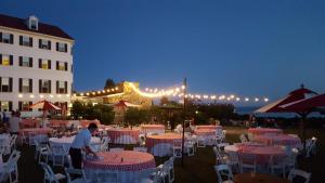 a group of tables and chairs in front of a building at The Colony Hotel Kennebunkport in Kennebunkport
