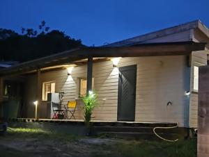 a small white house with a porch at night at Contain'House Paradise in Les Abymes