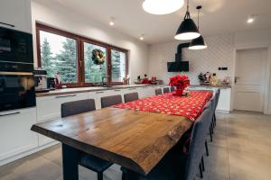 a kitchen with a wooden table with a red table cloth at Przygórze - dom w Górach Sowich in Przygórze