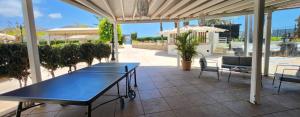 a patio with two tables and chairs and an umbrella at Ocean Front Cura Beach in Playa del Cura