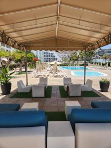 a pavilion with chairs and a swimming pool at Ocean Front Cura Beach in Playa del Cura