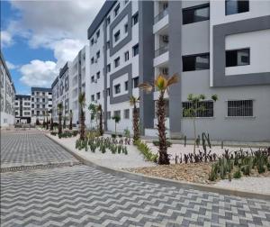 a courtyard with palm trees in front of a building at Massira Green Park Serenity in Kenitra