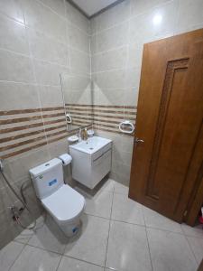 a bathroom with a toilet and a sink at Massira Green Park Serenity in Kenitra +3 photos