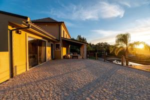 a house with a brick driveway next to a fence at Golden View in Vale de Tábuas