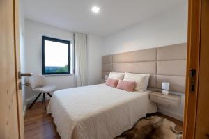 a bedroom with a large white bed with pink pillows at Golden View in Vale de Tábuas +22 photos