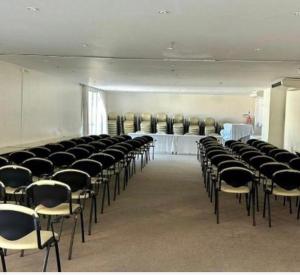 a room with rows of chairs and a row of tables and chairs at Mandai Apart - Beira Mar in Cabo Frio