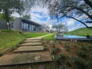 a house with a staircase next to a swimming pool at Quinta La Terquedad in Montemorelos