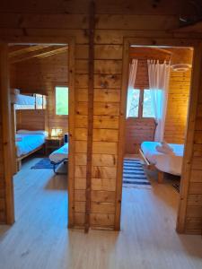 a room with two beds in a log cabin at La Cabaña Rural in Paúl