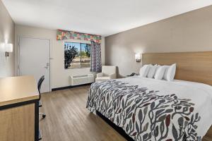 a hotel room with a bed and a desk and a window at Red Roof Inn Tucson - Vail in Tucson