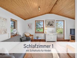a living room with white walls and a wooden ceiling at Ferienhaus Töpferhaus - strandnah, haustierfreundlich, Kaminofen, Garten, Platz für 3 Erwachsene, 2 Kinder in Steinberg