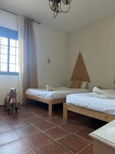 a bedroom with two beds and a stuffed animal on the floor at Casa Alboroto in Puebla del Río +53 photos