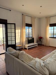 a living room with a couch and a television at Casa Alboroto in Puebla del Río