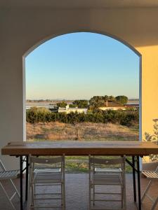 a table with two chairs and a large window at Casa Alboroto in Puebla del Río