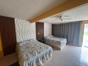 a bedroom with two beds and a ceiling fan at Hotel Acambay in Acambay +10 photos