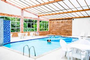 a swimming pool with a person in the water at Pousada Lusitânia in Pedra Azul
