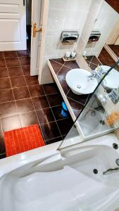 a bathroom with a white tub and a sink at EVASION Bungalow Tropical Spa in Sarraméa
