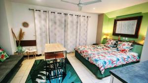 a bedroom with a bed and a couch and a table at EVASION Bungalow Tropical Spa in Sarraméa
