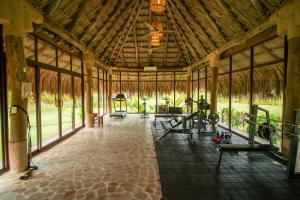 a gym with a large wooden building with people exercising on machines at Hotel Isla Mucura in Isla Mucura