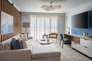 a living room with a couch and a flat screen tv at Tampa Airport Marriott in Tampa +54 photos