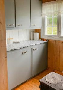 a kitchen with white cabinets and a counter top at Simple Mountain Cabin Near Vinstra in Vinstra