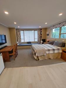 a bedroom with a bed and a desk and a television at Orchards Retreat in Paraparaumu Beach