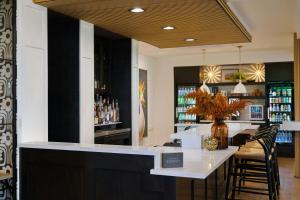 a bar with a white counter and some chairs at Tiller House, Laguna Hills, a Tribute Portfolio Hotel in Laguna Hills