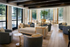 a living room with couches and tables and windows at Tiller House, Laguna Hills, a Tribute Portfolio Hotel in Laguna Hills