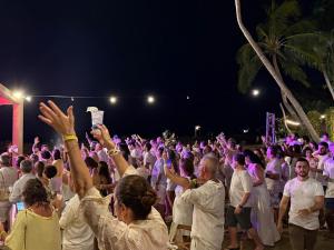 Eine große Menschenmenge mit erhobenen Händen in der Unterkunft Angá Beach Hotel in São Miguel dos Milagres + 263 Fotos
