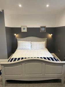 a bedroom with a large bed with a white bed frame at Apartment B in Bangor
