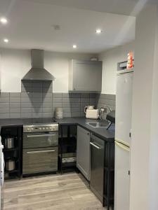 a kitchen with a sink and a stove top oven at Apartment B in Bangor