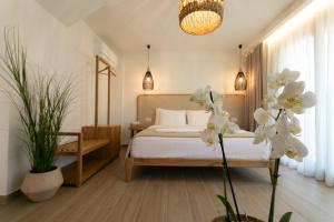 a bedroom with a bed with white sheets and flowers at Filoxenia Sea View in Parga +147 photos